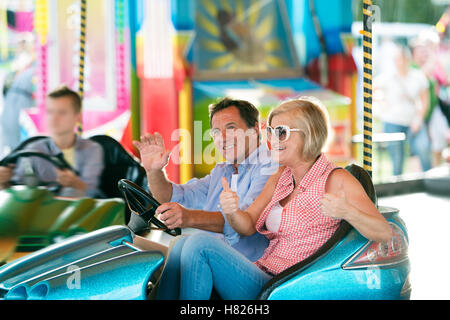 Couple dans le pare-choc voiture au fun fair Banque D'Images