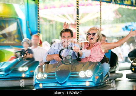 Couple dans le pare-choc voiture au fun fair Banque D'Images