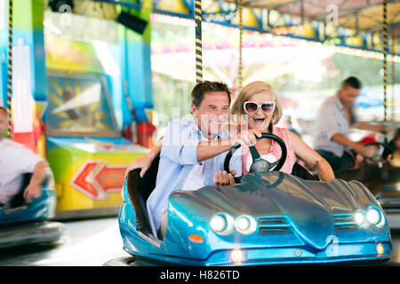 Couple dans le pare-choc voiture au fun fair Banque D'Images