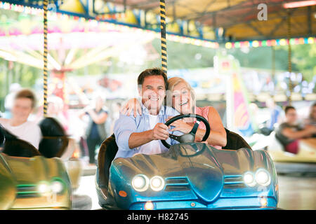 Couple dans le pare-choc voiture au fun fair Banque D'Images