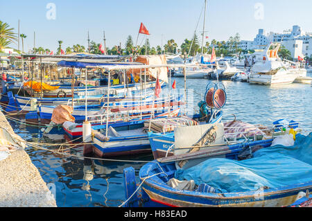 Le vieux port de pêche Bateaux amarrés près du bâtiment moderne cher yachts, El Kantaoui, Tunisie Banque D'Images