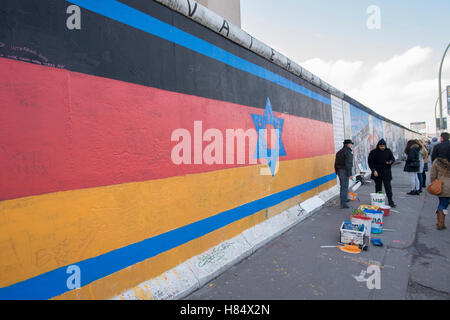 Berlin, Allemagne. 09Th Nov, 2016. Les gens passent devant la pièce 'patrie' à la East Side Gallery à Berlin, Allemagne, 09 novembre 2016. Artiste Guenther Schaefer a demandé à l'action pour l'anniversaire de l'ouverture du Mur de Berlin. Dans le passé, beaucoup de visiteurs à l'East Side Gallery griffonné à l'œuvre. Photo : PAUL ZINEKN/dpa/Alamy Live News Banque D'Images