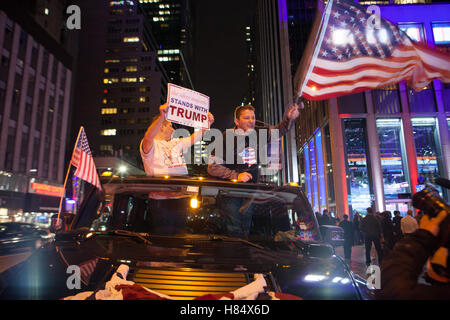 New York, USA. 09Th Nov, 2016. Donald Trump partisans en descendant de la 6e Avenue avec un drapeau américain à New York, USA, 09 novembre 2016. Photo : Alessandro Vecchi dpa/Alamy Live News Banque D'Images