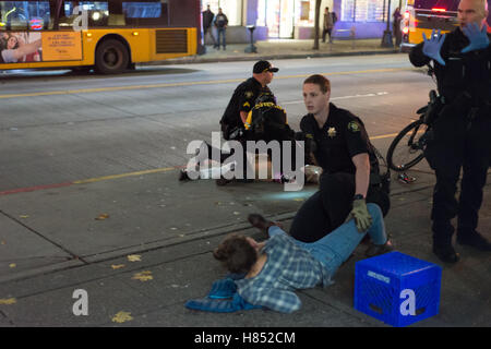 Seattle, USA. Nov 9, 2016. Une femme jette sur le sol après avoir été touché à la jambe pendant le tireur à Seattle le 9 novembre 2016. Credit : Jordanie Pickett/Alamy Live News Banque D'Images