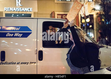 Chicago, Illinois, USA. 9 novembre, 2016. Un passant bloqué dans le trafic en raison de la protestation high fives un protestataire pour montrer son soutien. Credit : Caleb Hughes/Alamy Live News. Banque D'Images