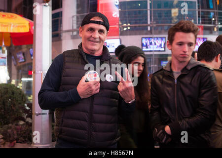 New York, NY, USA - 9 novembre 2016. 2:50 AM : un atout supporter (à gauche) victoire des gestes avec ses doigts tout en regardant le photographe à Times Square. Photo : Alessandro Vecchi dpa