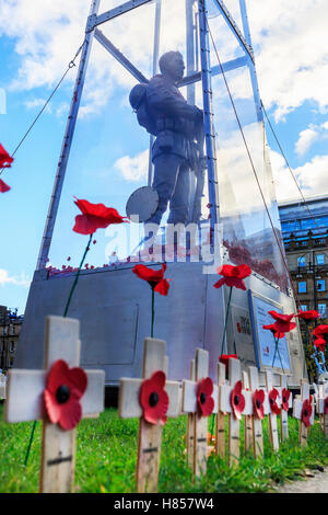 Glasgow, Ecosse, Royaume-Uni. 10 novembre, 2016. En préparation de la cérémonie du Souvenir le 11 novembre Services la statue de "chaque homme se souvint' par MARK HUMPHREY, a 23 pieds de haut statue en laiton du Soldat inconnu de verre et avec des centaines de coquelicots flottant dans le cas, est orné de Croix du Souvenir et de l'opium par les membres du public et à l'Écosse. La statue peut être vu à la cérémonie du jardin, George Square, Glasgow city centre. Credit : Findlay/Alamy Live News Banque D'Images