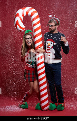 Couple debout à côté de la canne de Noël Banque D'Images