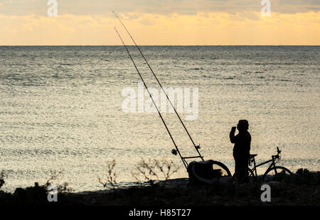 Silhouette de quelqu'un qui pêche en mer. Banque D'Images