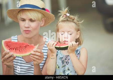 Mère et fille profiter de tranches de melon d'eau Banque D'Images