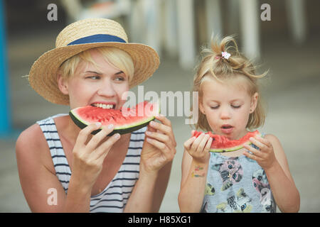 Mère et fille profiter de tranches de melon d'eau Banque D'Images