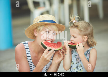 Mère et fille profiter de tranches de melon d'eau Banque D'Images