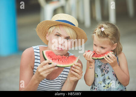 Mère et fille profiter de tranches de melon d'eau Banque D'Images