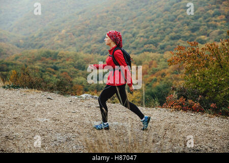 Jeune fille en voyage touristique sur un sentier de montagne à pied sous la pluie au cours de la Crimée marathon de montagne Banque D'Images