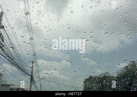 Chute de pluie sur la voiture vitre avec poteau et nuages dans le ciel Banque D'Images