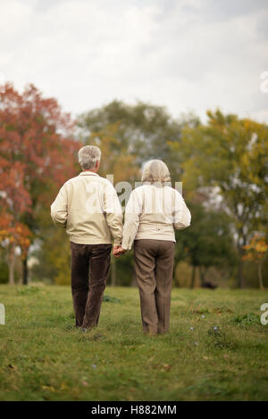 Couple de personnes âgées s'en va par l'allée du parc en automne Banque D'Images