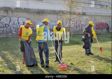 Milan (Italie), un groupe de réfugiés et demandeurs d'asile de nettoyer les parcs de la ville des travaux de bénévolat Banque D'Images