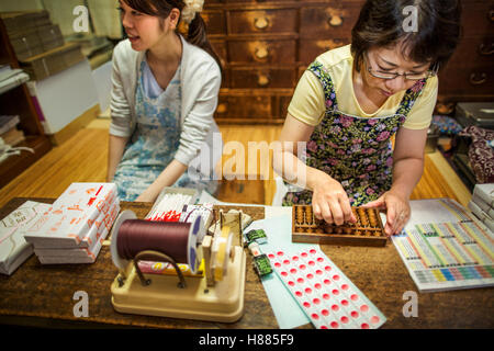 Un petit producteur artisan spécialiste de la traite, des bonbons appelé wagashi. Deux femmes travaillant pour la livraison d'emballage boîtes sucré. Banque D'Images