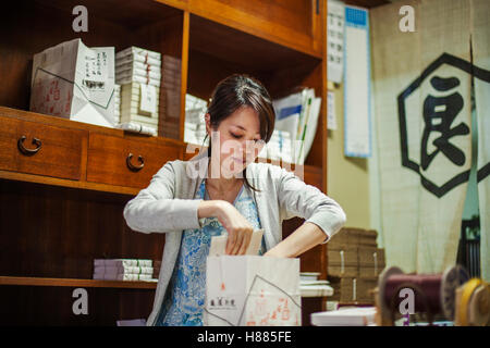 Un petit producteur artisan spécialiste de la traite, des bonbons appelé wagashi. Une femme travaillant pour la livraison d'emballage boîtes sucré. Banque D'Images