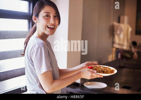 Femme tenant un plat de nouilles soba dans une boutique. Banque D'Images