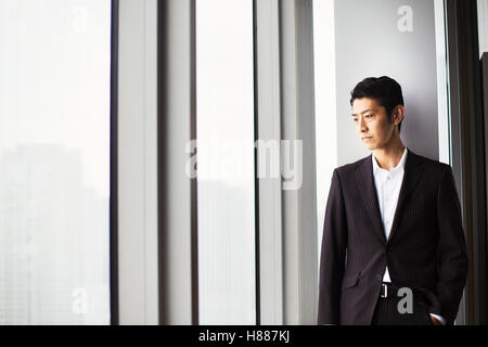 L'homme d'affaires de l'office, par une grande fenêtre, vue sur la ville. Banque D'Images