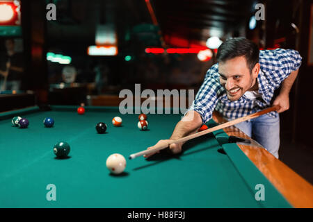 Bel homme jouant au billard dans un pub Banque D'Images