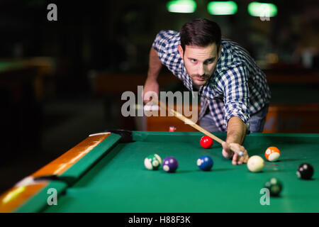 Bel homme jouant au billard dans un pub Banque D'Images