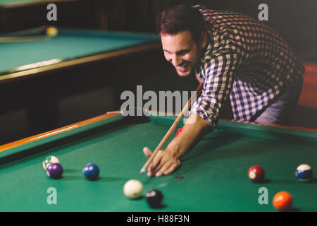 Bel homme jouant au billard dans un pub Banque D'Images