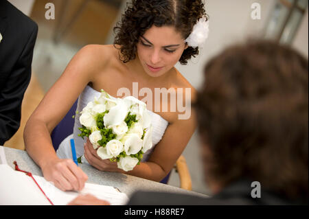 Cérémonie civile, épouse de signer un certificat de mariage au bureau d'enregistrement Banque D'Images