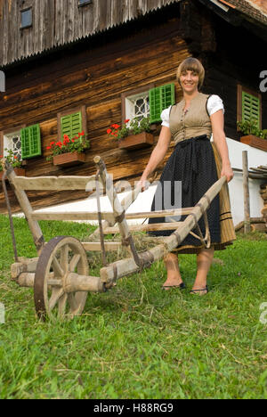 Farmwoman avec une brouette dans une ferme Banque D'Images