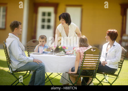 Restaurant Le Jardin avec la famille et serveuse Banque D'Images