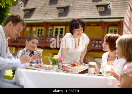 Restaurant Le Jardin avec la famille et serveuse Banque D'Images