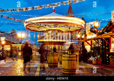 Les gens sur le marché de Noël sur la place Rouge dans le centre-ville de Moscou, la Place Rouge lumineux et décoré pour Noël à Moscou. Marché de Noël sur balançoires carrousel Banque D'Images