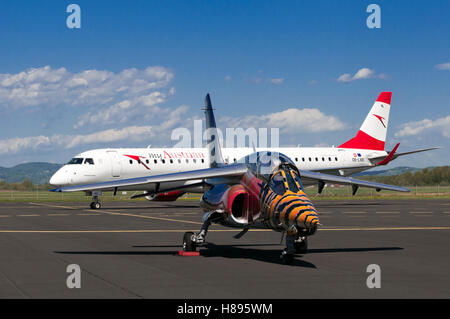 Maribor, Slovénie - 16 Avril 2016 : Red Bull Alpha Jet en face et Austrian Airlines Embraer OE-LWD sur tablier à l'aéroport Maribor Banque D'Images