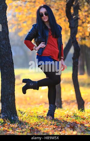 Fille à bascule dans la forêt d'automne en lunettes noires Banque D'Images