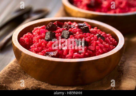 Risotto de betterave préparée avec de la purée de betterave betteraves rôties, morceaux sur le dessus, photographiés avec lumière naturelle Banque D'Images