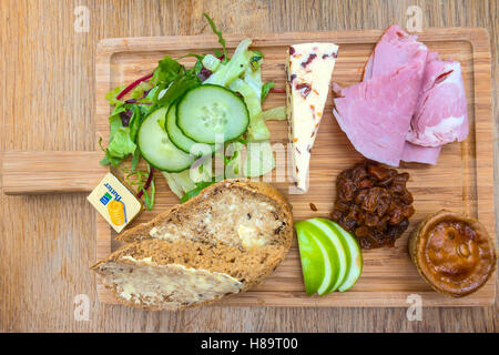 Un déjeuner traditionnel du laboureur de jambon de porc au fromage Salade Tarte Pickle et pain et beurre servi sur un plateau en bois dans un café dans le Yorkshire du Nord Banque D'Images