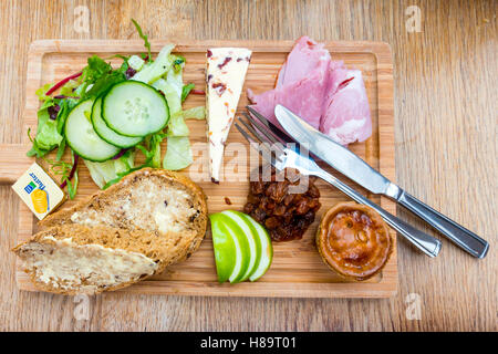 Un déjeuner traditionnel du laboureur de jambon de porc au fromage Salade Tarte Pickle et pain et beurre servi sur un plateau en bois dans un café dans le Yorkshire du Nord Banque D'Images