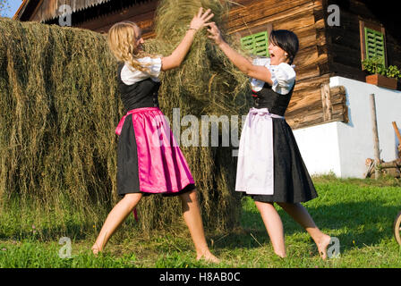 Jeune femme portant deux robes Dirndl foin récolte Banque D'Images