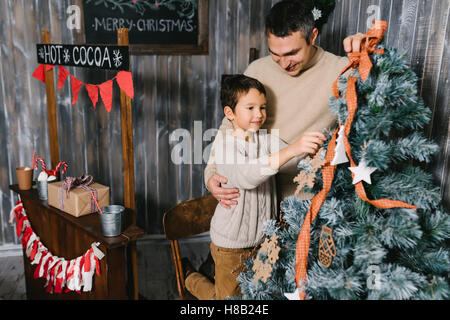 Fils et père de décorer l'arbre de Noël à la maison Banque D'Images