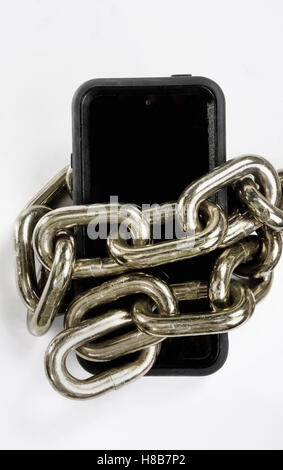 Cellphone enfermés dans la chaîne en laiton en noir et blanc. Banque D'Images