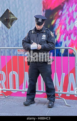 Agent de police de la ville de New York écrit un billet sur Broadway à Times Square, Manhattan, New York City Banque D'Images