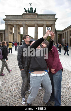 Groupe de jeunes hommes qui déploient des Selfies Devant la porte de Brandebourg en Allemagne Banque D'Images