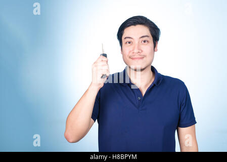 Asian man holding, montrant les clés de sa nouvelle voiture, sur fond bleu Banque D'Images