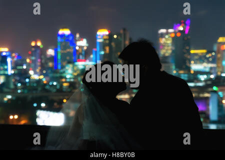 Silhouette d'Asian couple mariage au moment romantique floue sur sombre nuit ville au centre-ville historique. Amour saint valentin mariage sto Banque D'Images