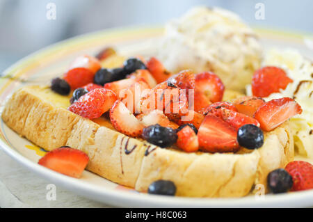 Pain doré avec garniture aux fraises, myrtilles et crème glace lave Banque D'Images