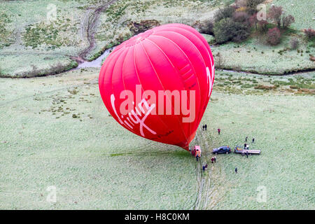 Une Vierge hot air balloon décollant d'un champ dans la vallée supérieure de Dove, Peak District National Park Banque D'Images