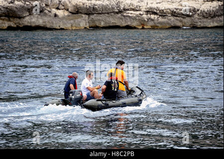 Quatre hommes en mer sur un petit bateau pneumatique bateau à moteur dans les calanques de Marseille de Parc National Banque D'Images