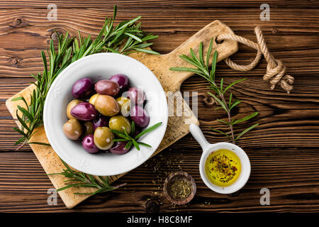 Ingrédients alimentaires italiennes, romarin, olives, huile d'olive sur fond de bois Banque D'Images