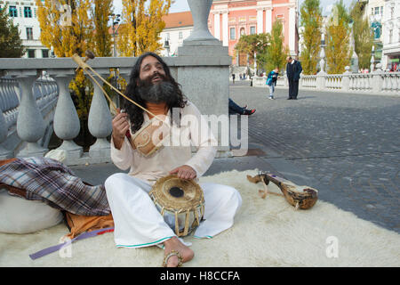 L'homme était assis sur un tapis indien, chantant et jouant (Iktara ou ektara) - un instrument à cordes, à triple pont, la rivière Ljubljanica, L Banque D'Images